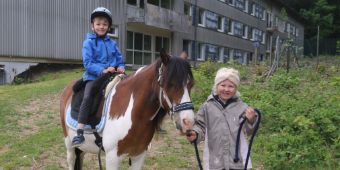 Das Motiv zeigt zwei Kinder auf einem Pony