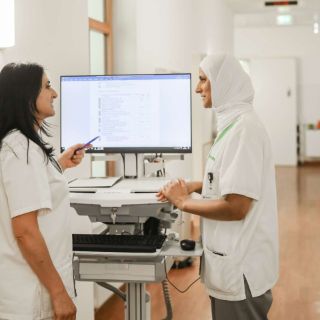 Zwei Pflegekräfte besprechen sich am Computer